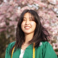 An image of Vicky Chen wearing her green graduation garb.